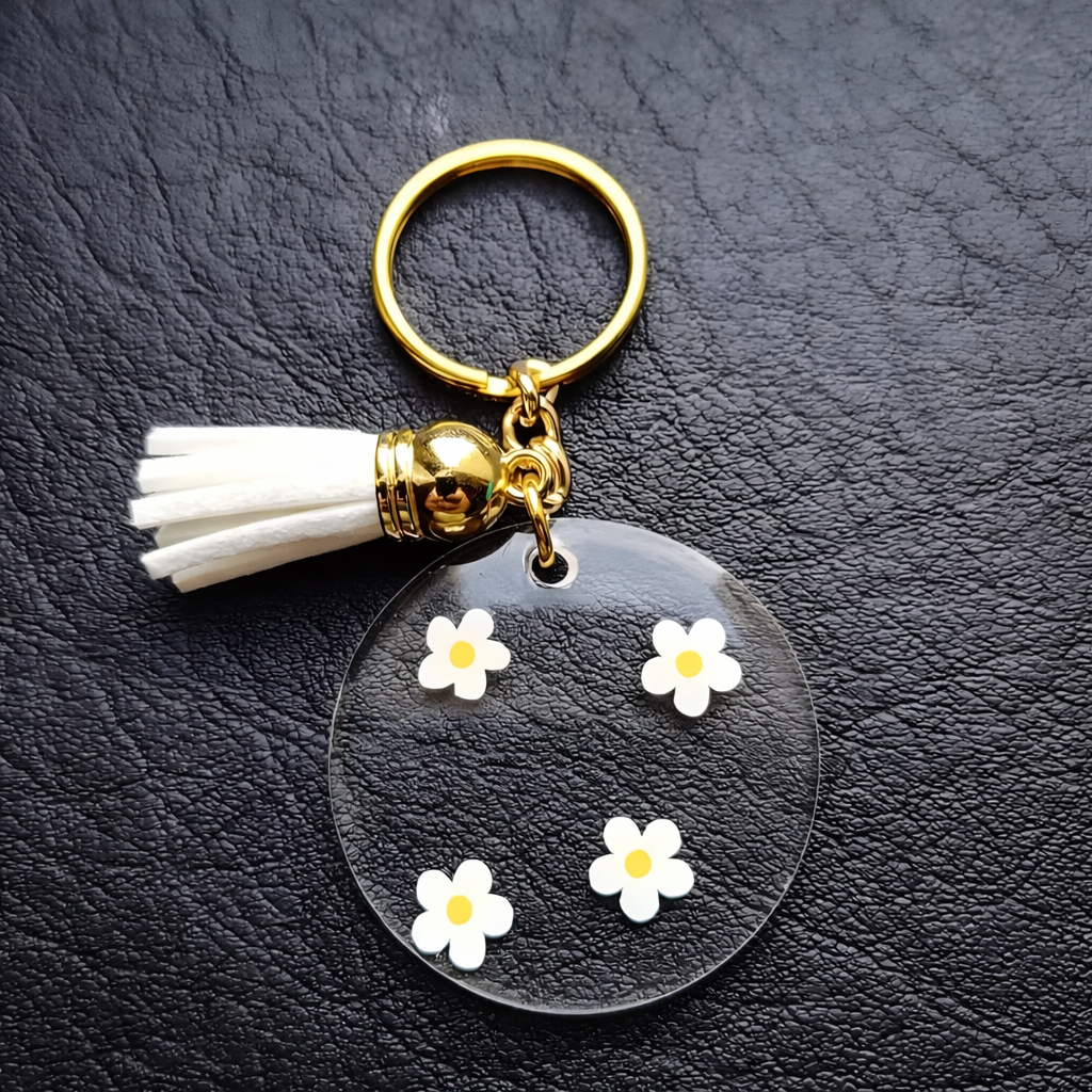 Porte-clés personnalisé rond en acrylique – Prénom doré avec fleurs marguerites et pompon élégant