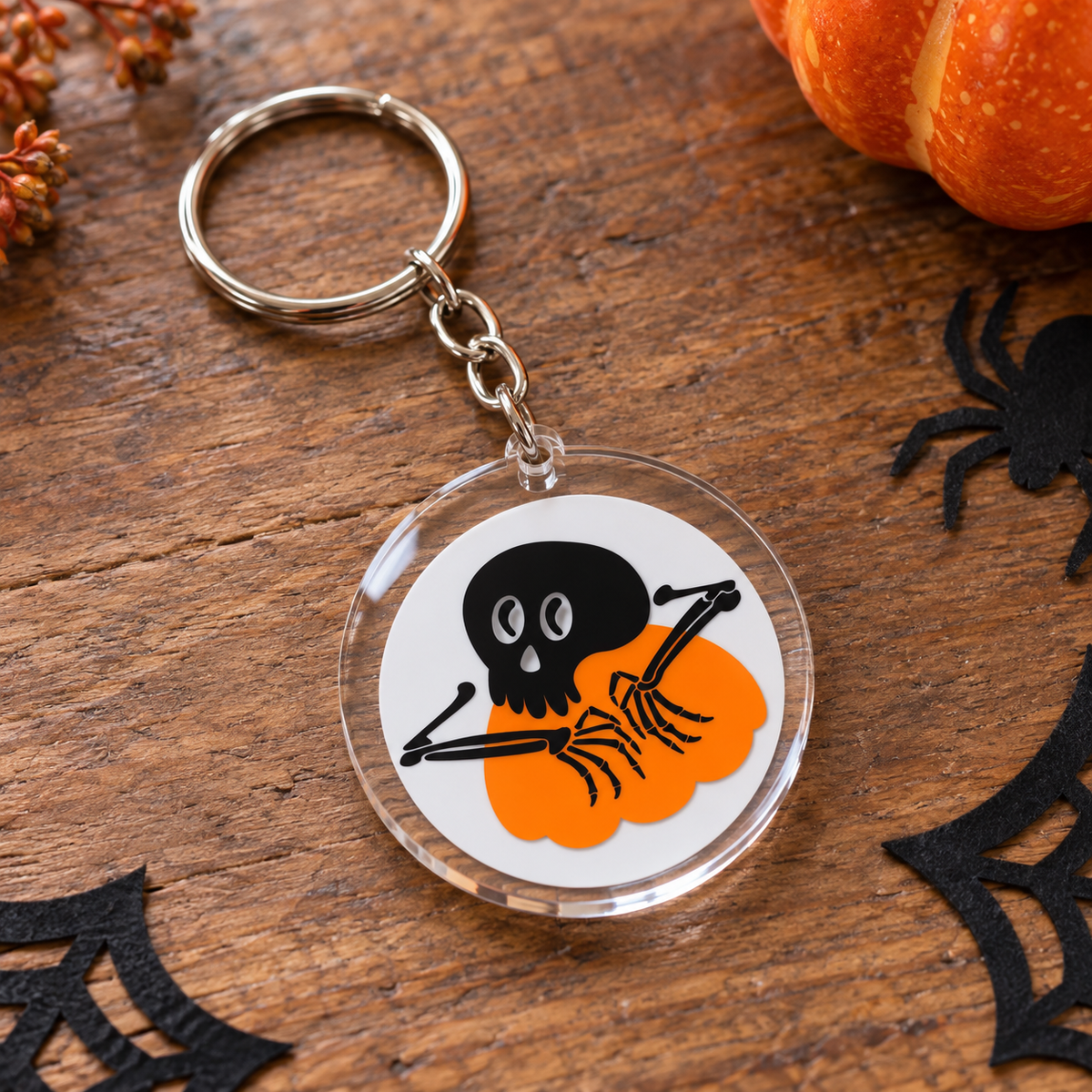 Porte-clés Halloween rond en acrylique squelette tenant une citrouille orange