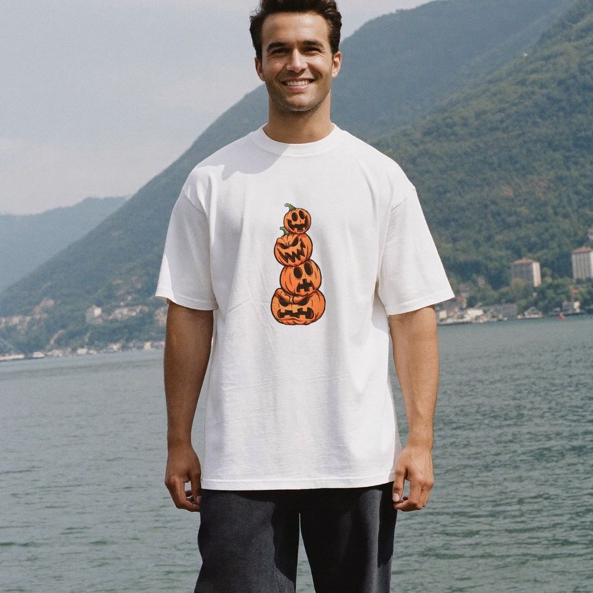 Homme portant le t-shirt oversize blanc Halloween vue de face - tour de trois citrouilles sculptées sur la poitrine