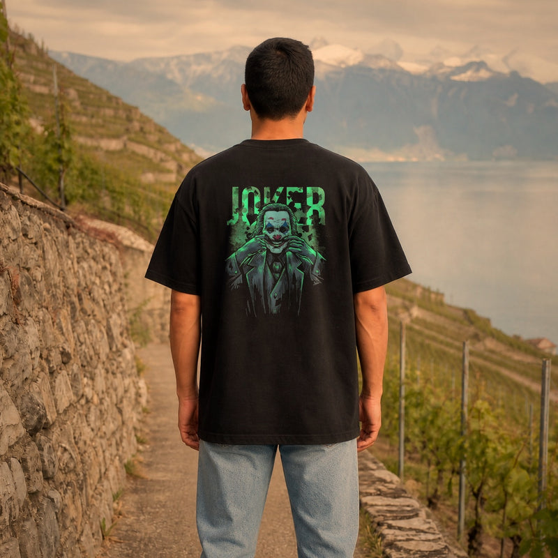 Homme portant le t-shirt oversize noir vue de dos - grand imprimé clown vert néon style comics, vignes de Lavaux
